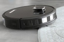 lifestyle image of a robot vacuum cleaning a rug
