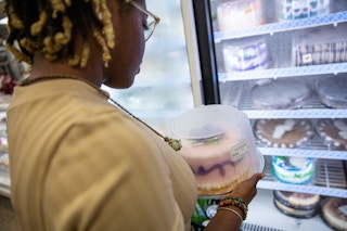 someone choosing an ice cream cake from the freezer at the Publix bakery