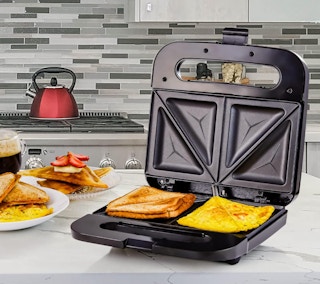 a sandwich press with eggs and toast on a counter