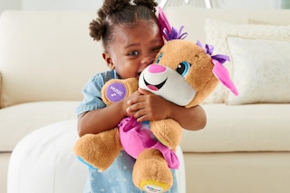 a girl playing with a fisher-price plush