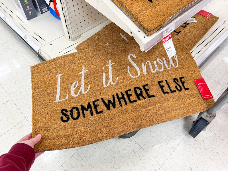 hand holding wondershop christmas doormat near target shelf