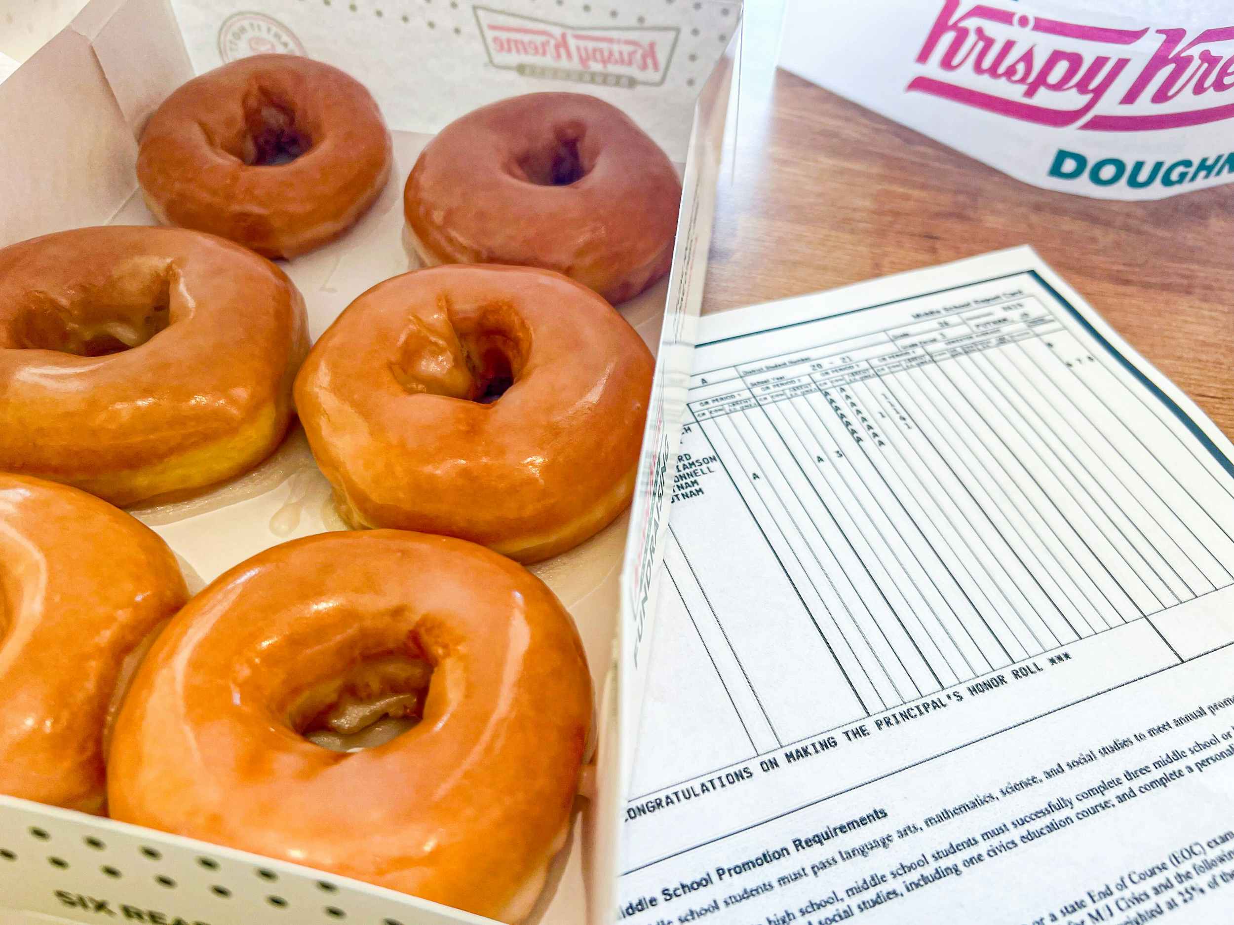 krispy kreme donuts next to a child's report card