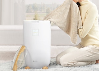 a person pulling out a towel from a towel warmer