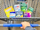 hand pushing a walmart shopping cart with opella brand health and wellness products