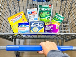 hand pushing a walmart shopping cart with opella brand health and wellness products