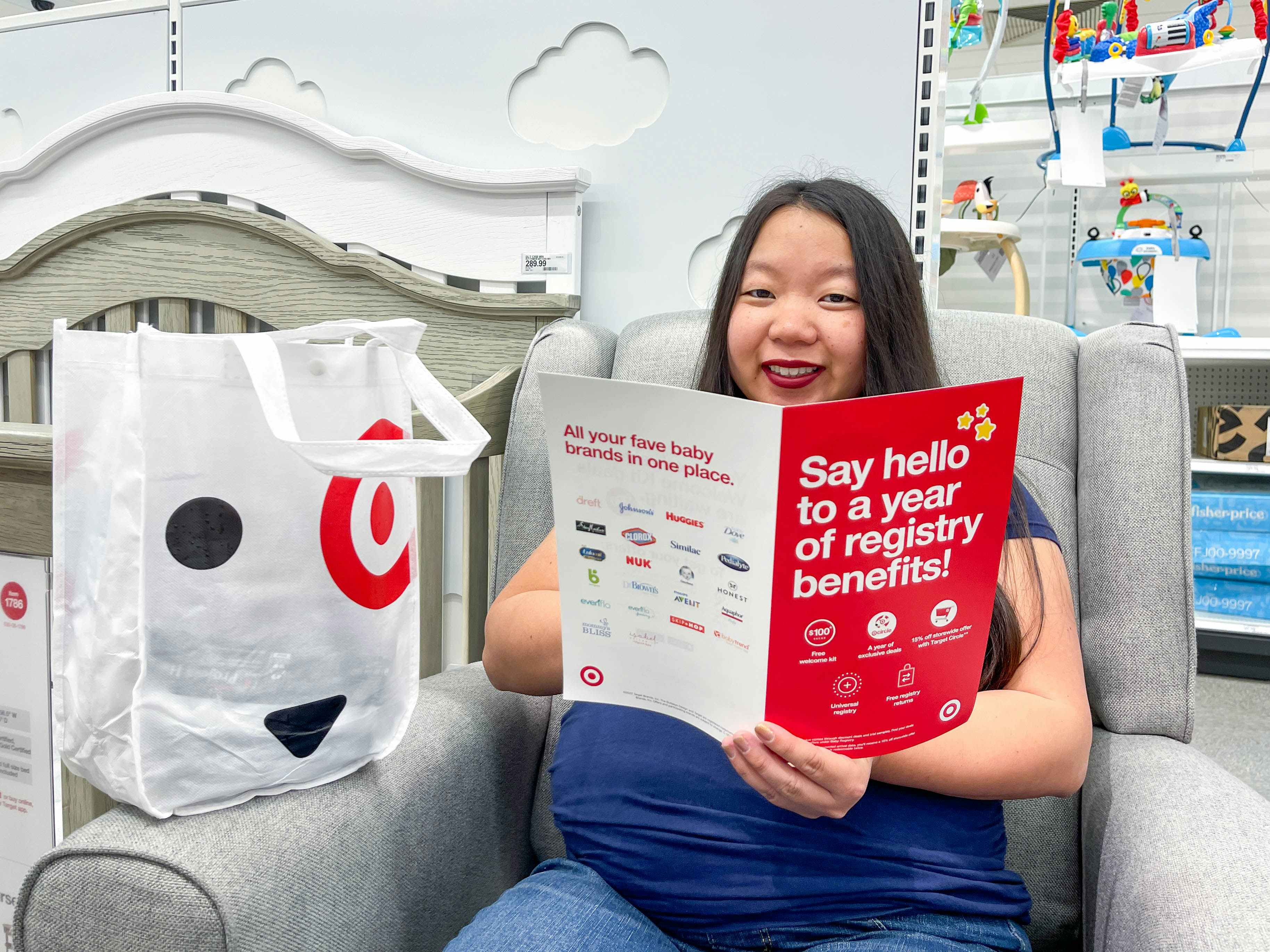 a woman sitting down with a target baby registry welcome bag and brochure