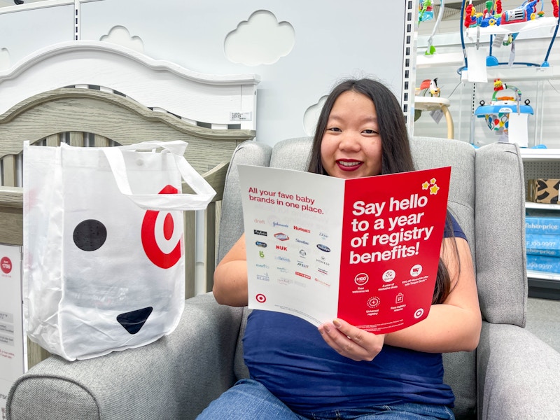 a woman sitting down with a target baby registry welcome bag and brochure