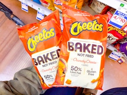 hand holding two bags of baked cheetos