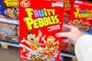 hand holding a box of post fruity pebbles cereal