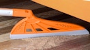 an orange magic broom picking up dirt