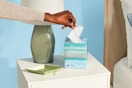 woman pulling a tissue out of box
