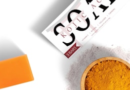 a bar of soap next to a bowl of turmeric 
