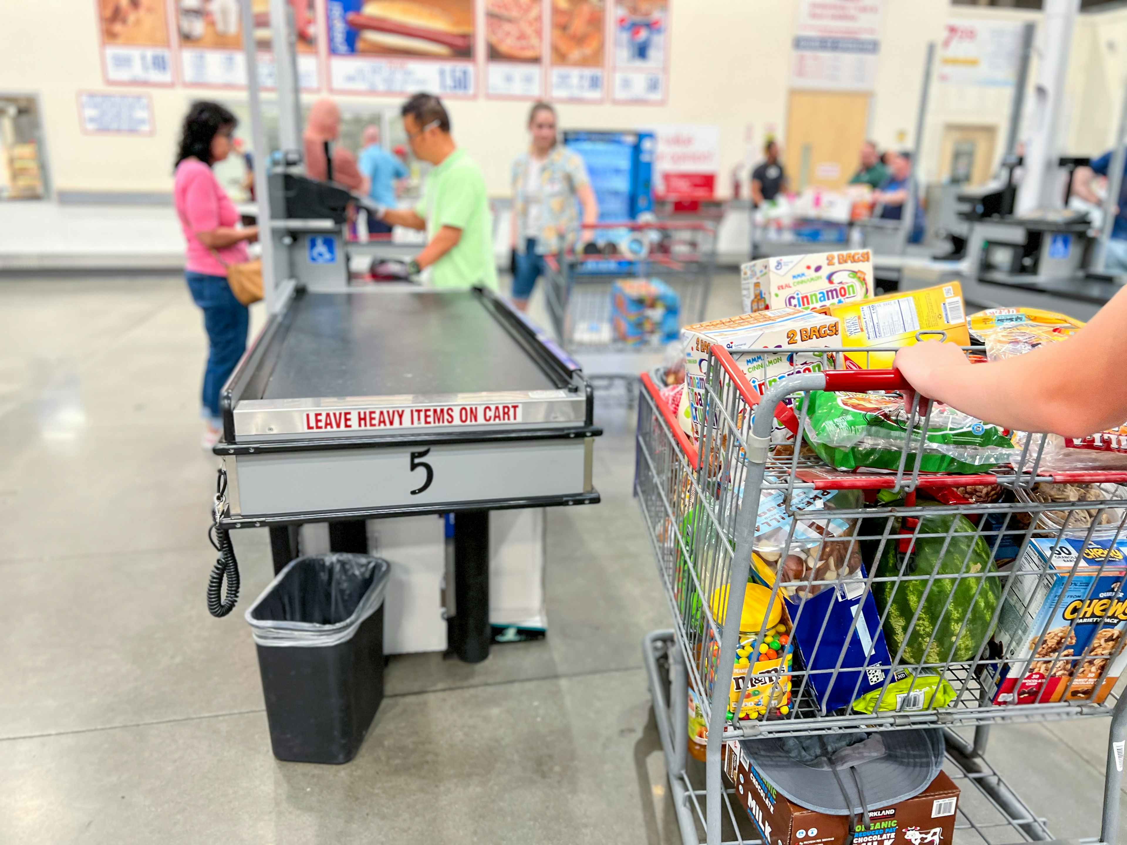 costco shopping cart with items in checkout lane