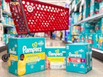 3 pampers boxes sitting a floor in front of parked target cart