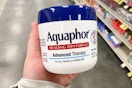 hand holding a jar of aquaphor healing ointment
