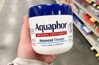 hand holding a jar of aquaphor healing ointment