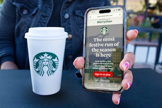 starbucks for life merrython on phone next to a starbucks cup