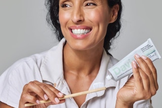 a woman using davids toothpaste