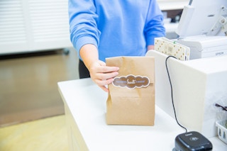 Nothing Bundt Cake employee handing off a bag