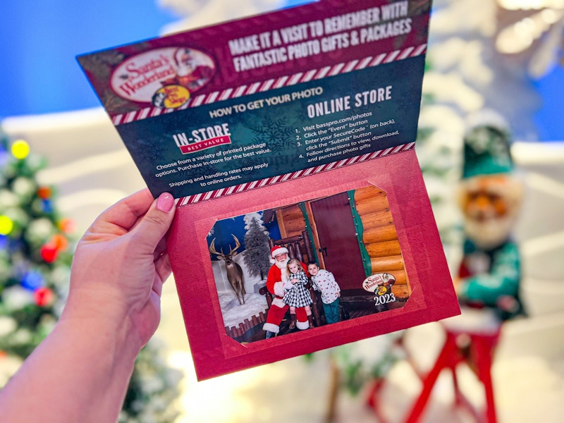 someone holding up a print of their kids posing with Santa at Bass Pro Shops