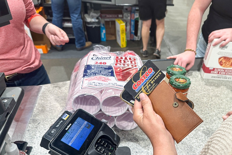 a person holding up a costco membership card