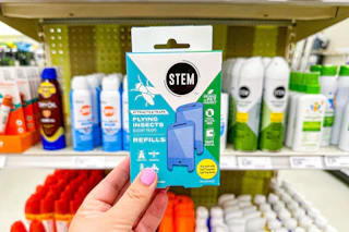 hand holding a stem flying insect light trap refill in front of a target shelf