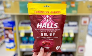 hand holding bag of halls cherry cough drops