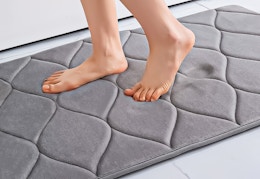 Lifestyle image of the black Smiry memory foam bath mat (close up shot of someone standing on it)