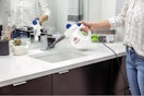 lifestyle image of person using a bissell steamshot cleaner on a bathroom faucet