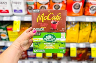 person holding mccafe and green mountain kcups