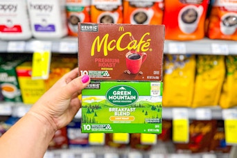 person holding mccafe and green mountain kcups