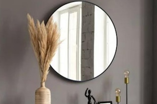 lifestyle image of a round wall mirror