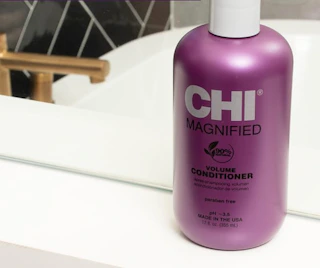a purple bottle of contioner on a bathroom sink