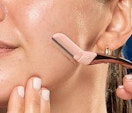Woman using the Schick dermaplanning razor.