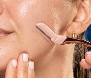 Woman using the Schick dermaplanning razor.