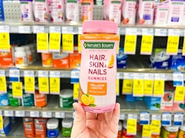 hand holding nature's bounty  hair skin and nails gummies