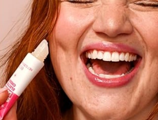 a person with a tube of lip balm near their face