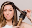 a person blow drying their hair with a copper air styler