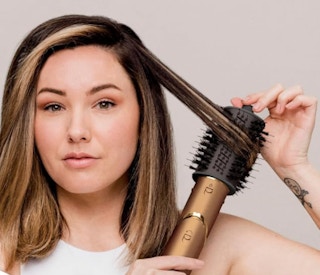 a person blow drying their hair with a copper air styler
