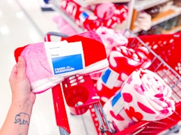 hand holding a valentine's day throw blanket in front of a target cart