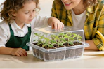child and parent using seed starter tray