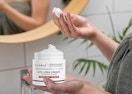 a person holding a jar of urea cream 