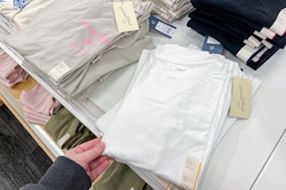 hand holding a section of women's tops at target