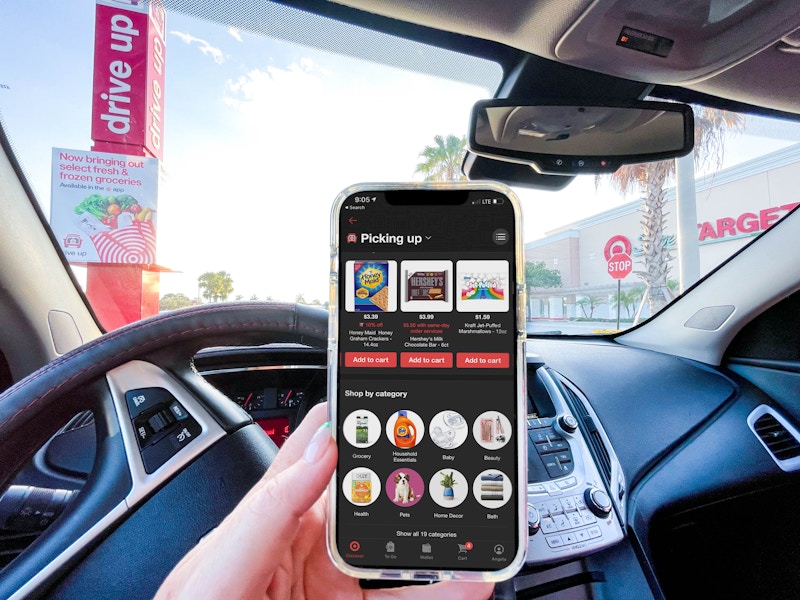 hand holding cellphone with app in car at target drive up parking