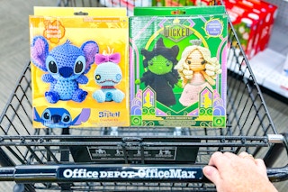 person pushing a cart with lilo & stitch and wicked crochet kits in it