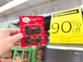 hand holding ornament hooks in walmart aisle