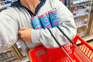person holding Eboost energy drinks and a shopping basket