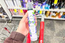 person holding herbal essences mousse over a cart