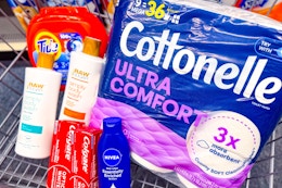 tide pods, cottonelle toilet paper, raw sugar body wash, colgate toothpaste, and nivea lotion in a cart