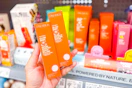 hand holding two orange boxes of Pacifica Baby Serum